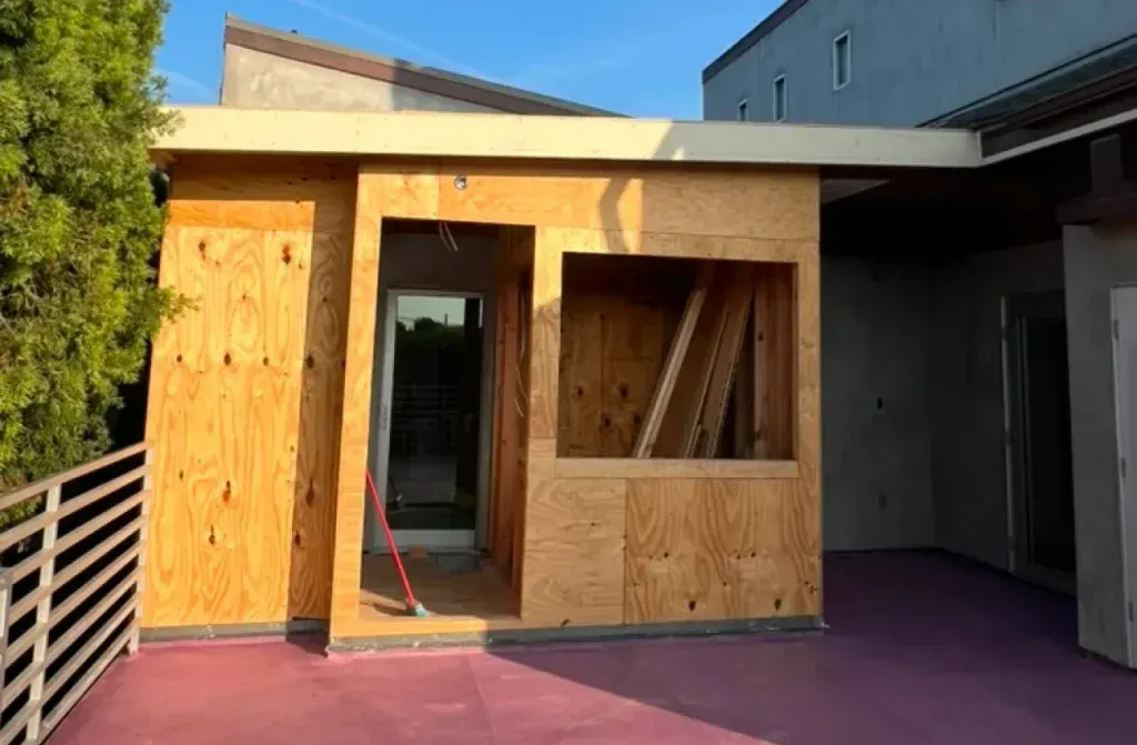 A small wooden building is being built on the side of a building.