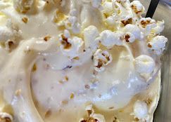 Primo piano di popcorn mescolati in una ciotola di dessert o salsa cremosa e di colore chiaro.