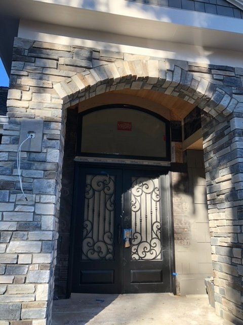 A brick building with a wrought iron door — Tukwila, WA — Bel-Red Windows & Doors