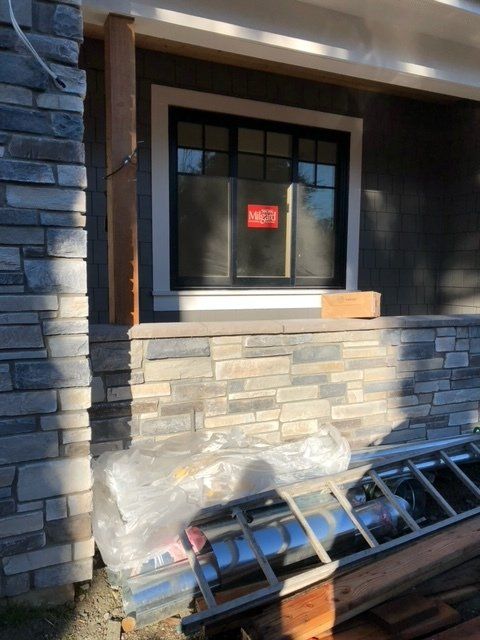 A ladder is sitting on the side of a building next to a window — Tukwila, WA — Bel-Red Windows & Doors