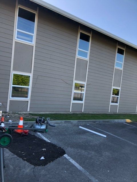 A large building with a lot of windows is in a parking lot — Tukwila, WA — Bel-Red Windows & Doors