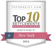 Top 10 Personal Injury Settlements in New York, 2022, awarded to Sayeqh & Sayeqh, P.C., with a pink ribbon and a star.