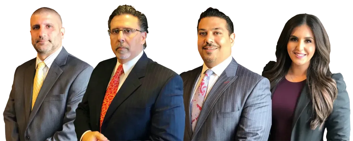 Four business professionals in suits, smiling at the viewer against a white background.