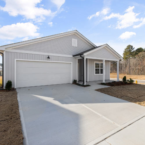 Gray house with a two-car garage and a small porch. Sunny day.