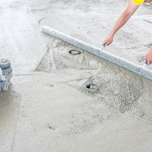 Person using a level to smooth wet concrete.