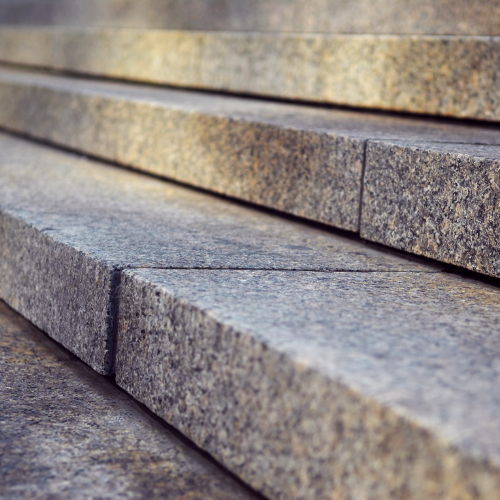 Stone steps, close-up, textured grey, angled perspective, leading upwards, sunlit.