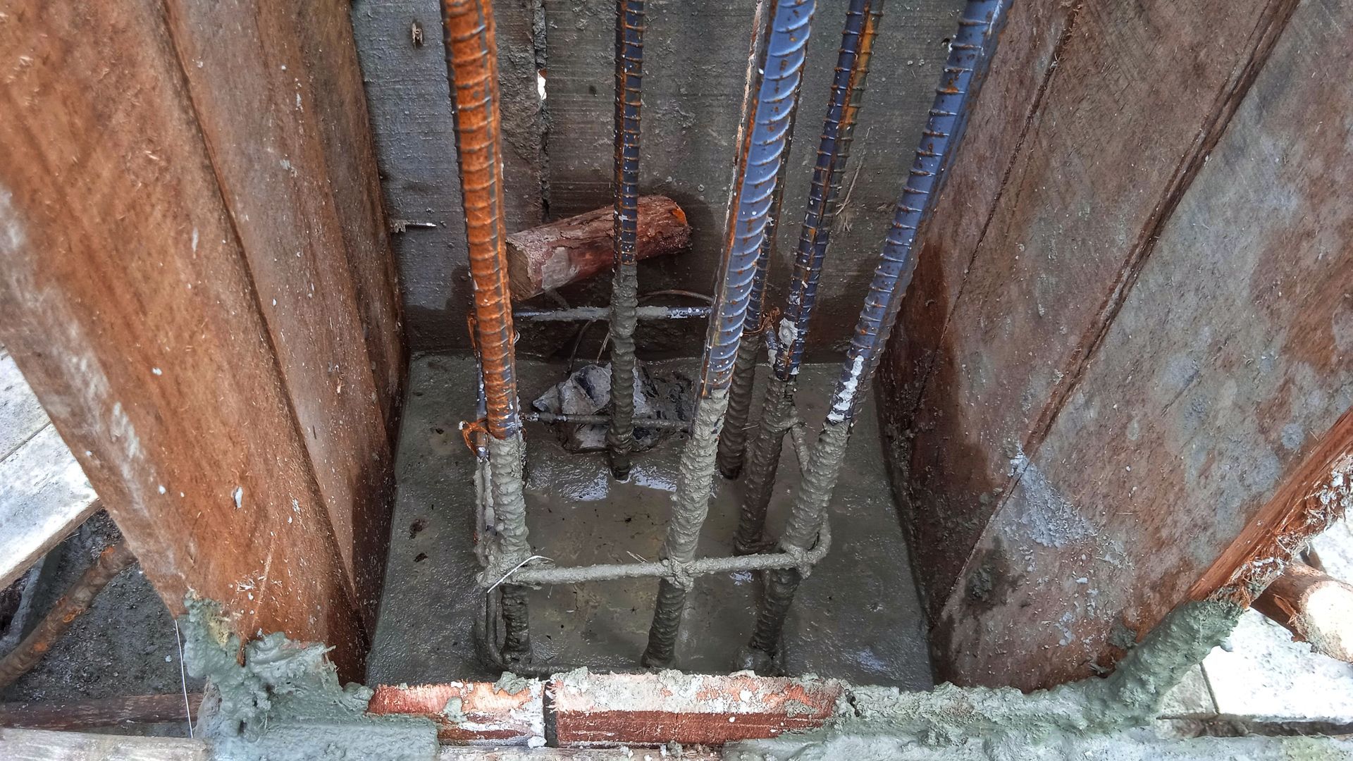 Wooden formwork with rebar for a concrete column under construction.