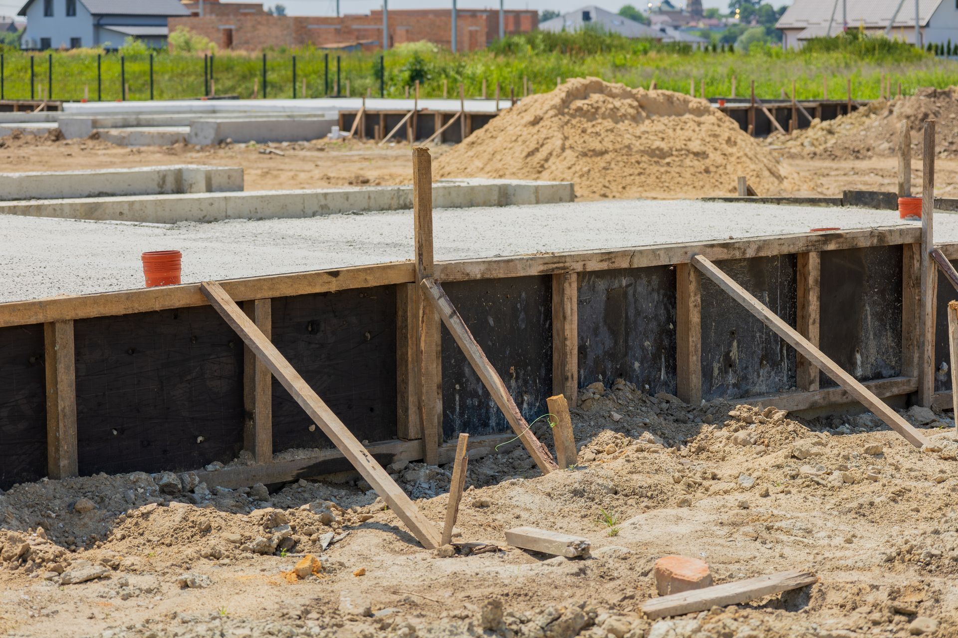 Foundation of a building under construction; wooden frame with supports, filled with concrete.