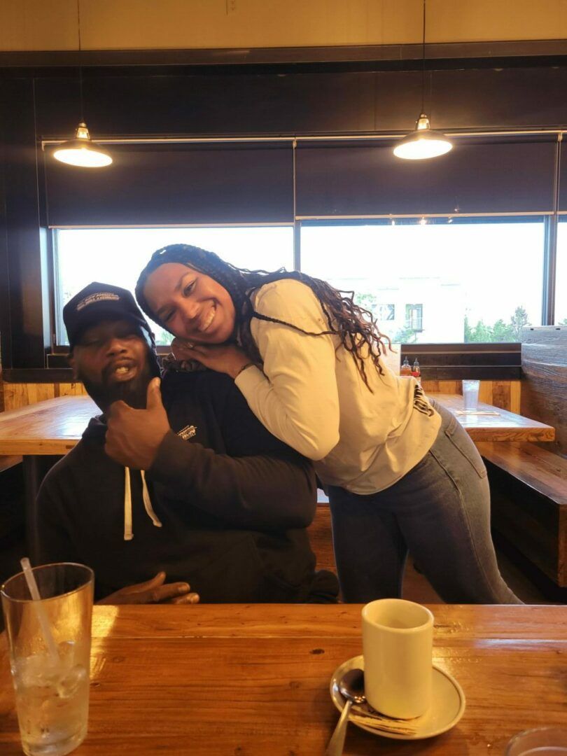 A man and a woman are posing for a picture in a restaurant