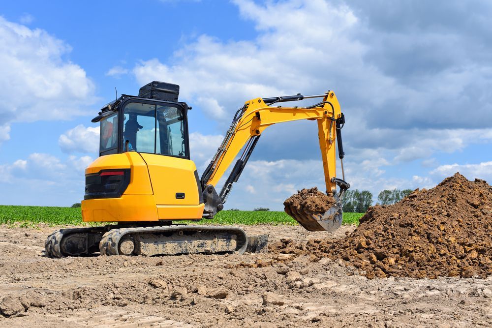 Yellow Excavator Digging Dirt on a Sunny Day Tracks, Bucket, and Mound of Soil Visible — Hannant Plant Hire in Brisbane, QLD