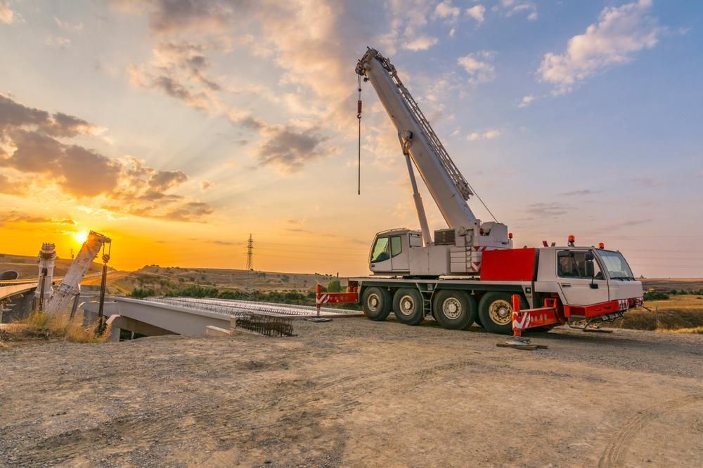 Large Crane is Parked on the Side of the Road at Sunset — Hannant Plant Hire in Robina, QLD