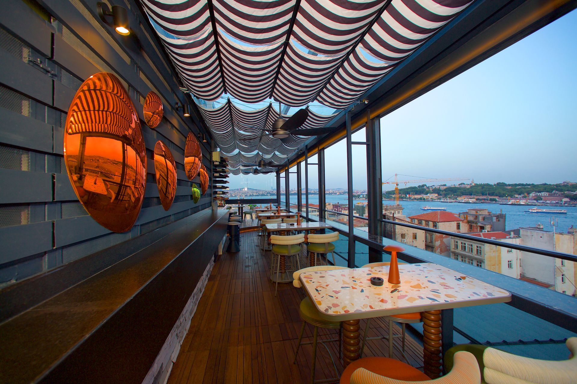 A restaurant with tables and chairs and a view of the ocean