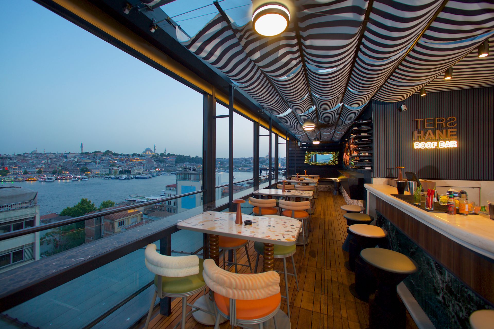 A restaurant with tables and chairs overlooking a body of water.