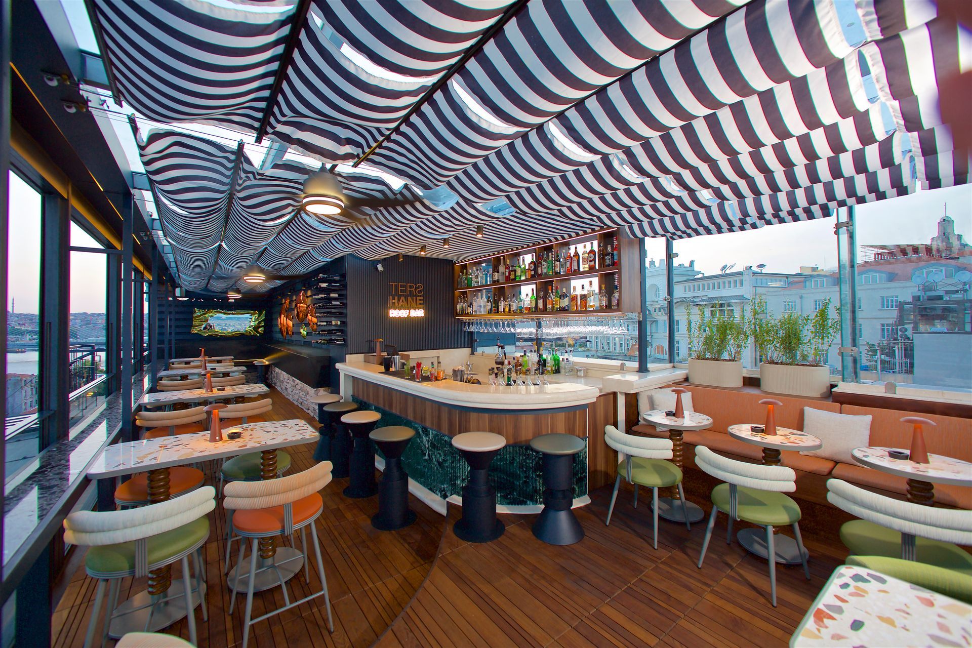 A restaurant with tables and chairs and a striped ceiling