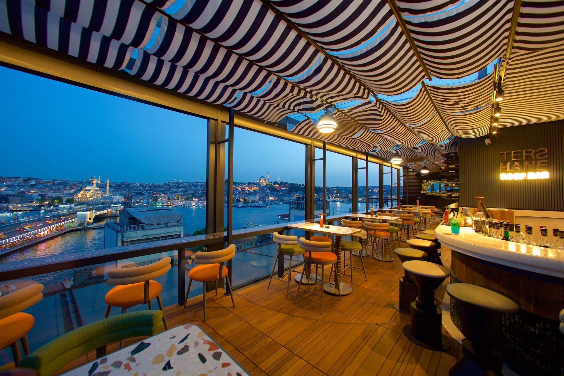 A restaurant with tables and chairs overlooking a body of water