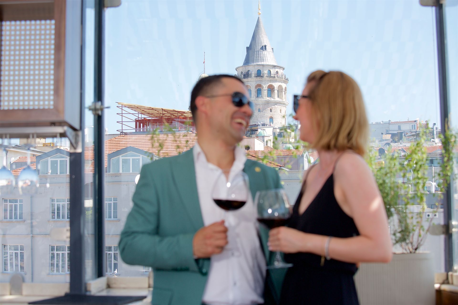 A man and a woman are standing next to each other holding wine glasses.