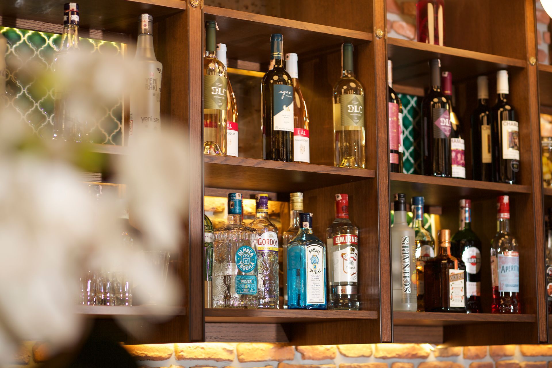 A bar with lots of bottles of alcohol on the shelves