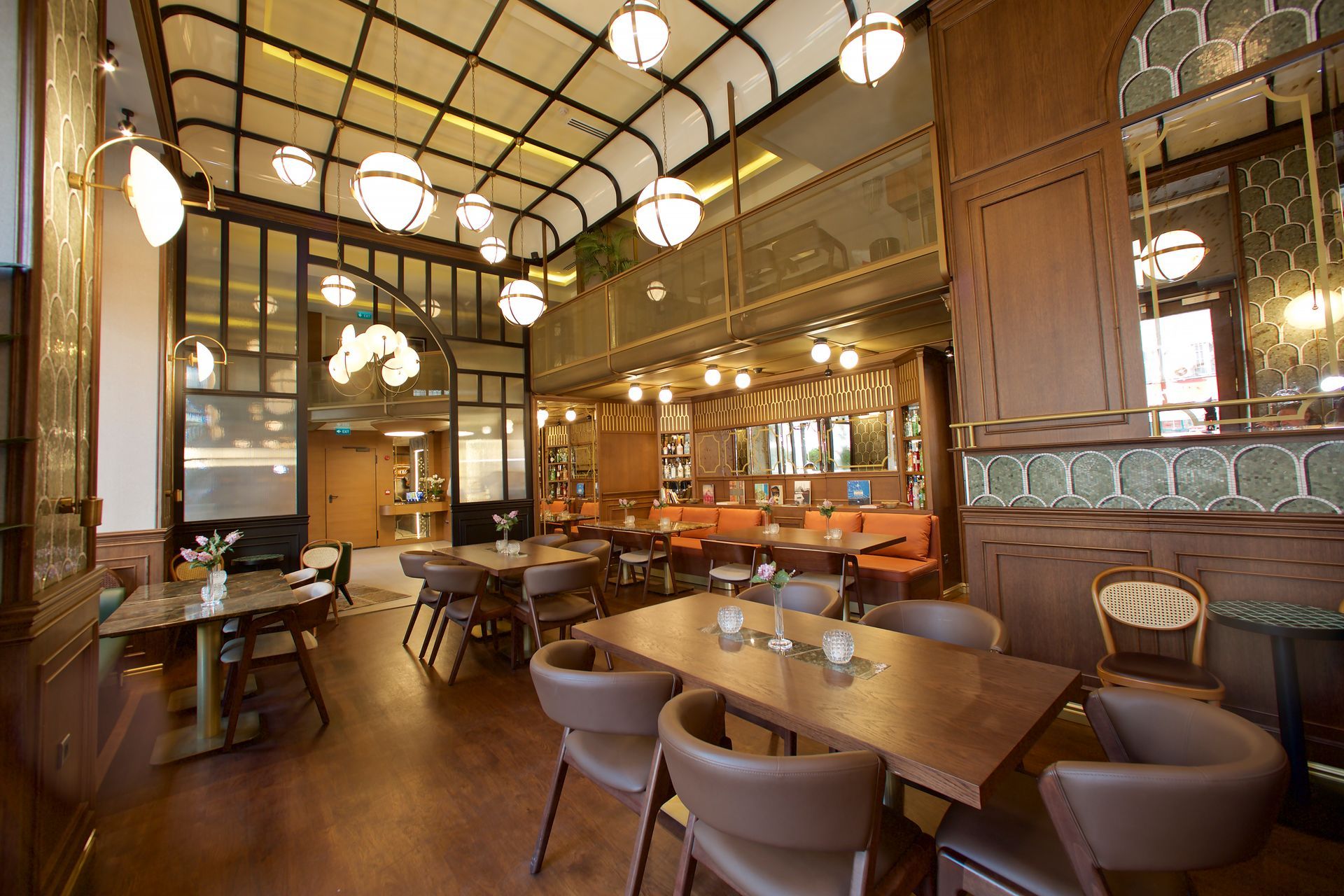 A restaurant with tables and chairs and a balcony.