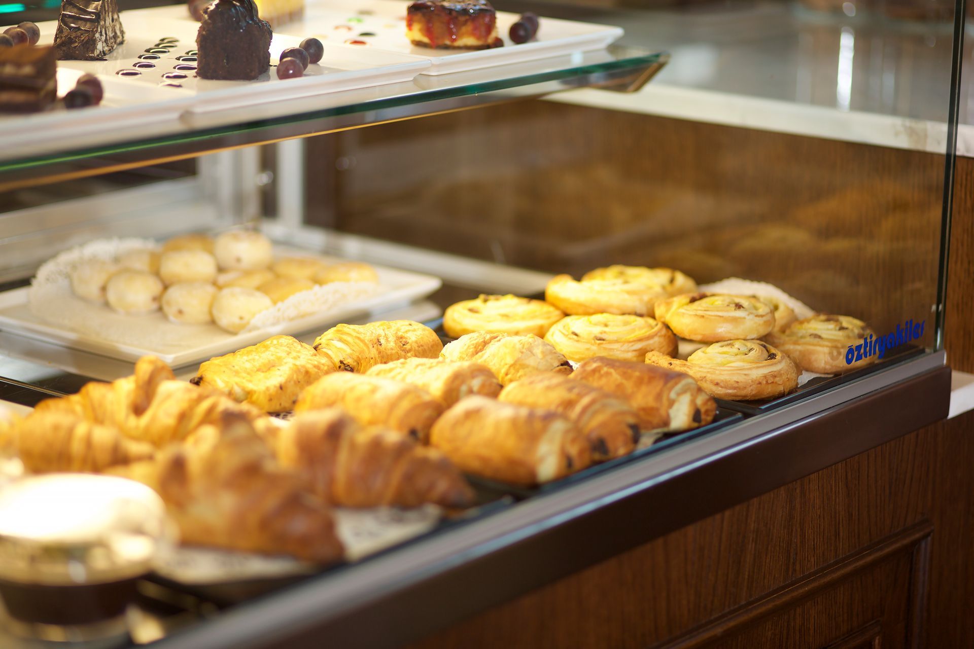 A display case filled with a variety of pastries and desserts.