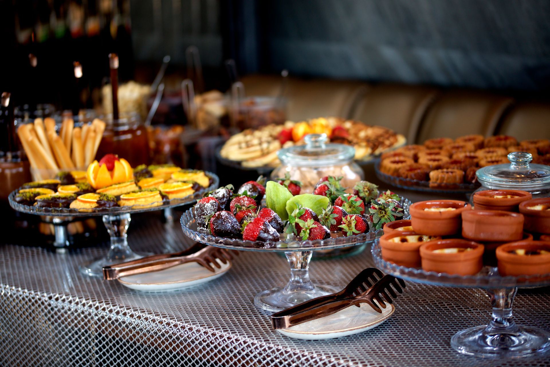 A table topped with a variety of desserts and fruit.