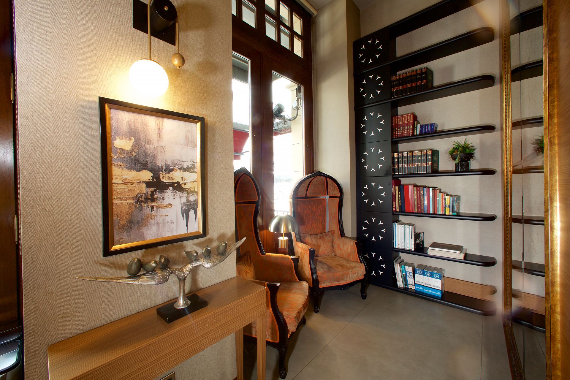 A living room with a table , chairs , shelves and a painting on the wall