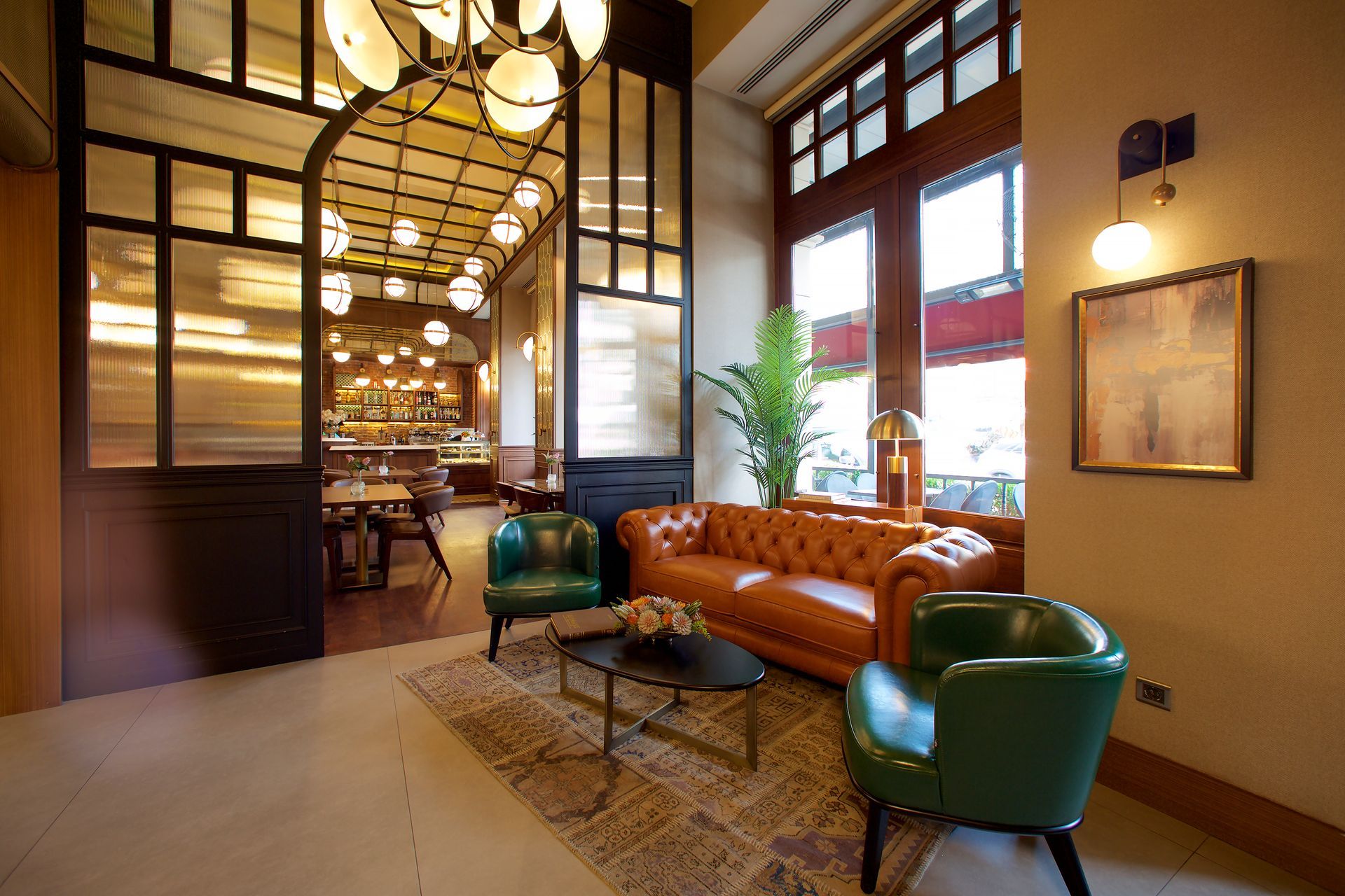 A living room with a brown couch and green chairs, momento hotels beyazıt images