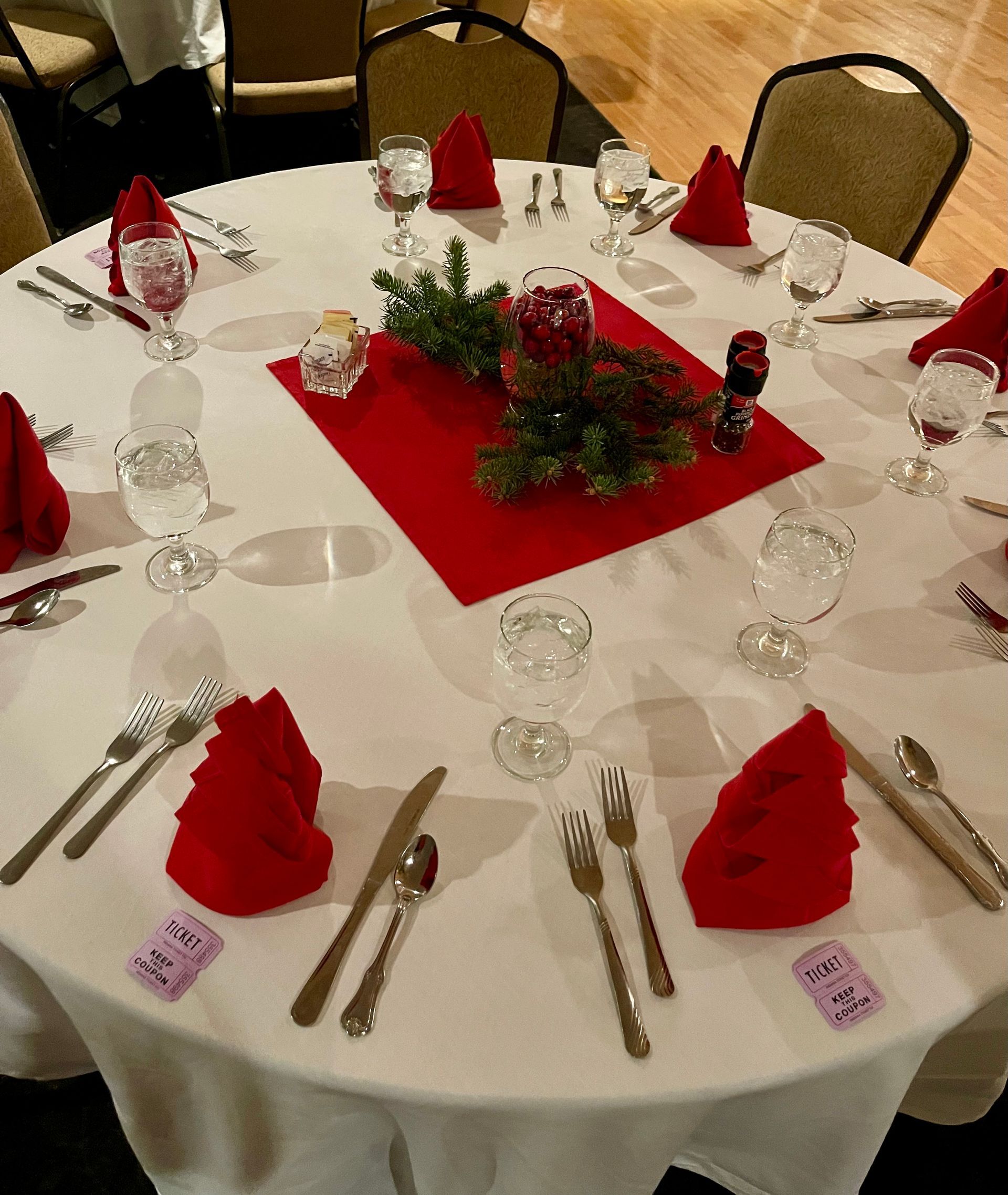 A round table with red napkins and silverware on it