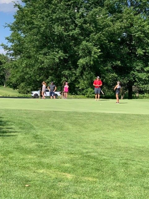 A group of people are playing golf on a golf course.