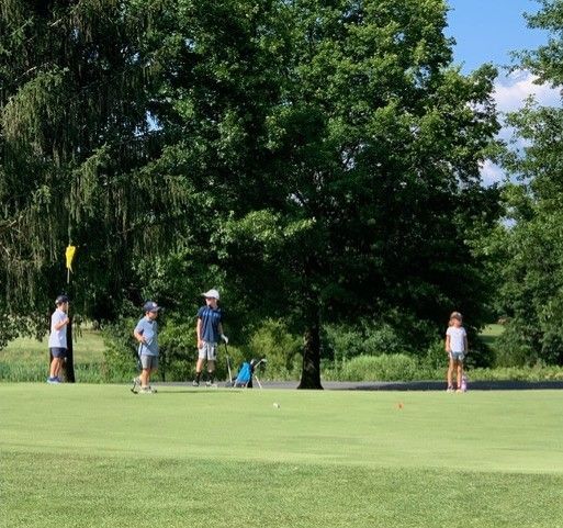 A group of people are playing golf on a golf course.