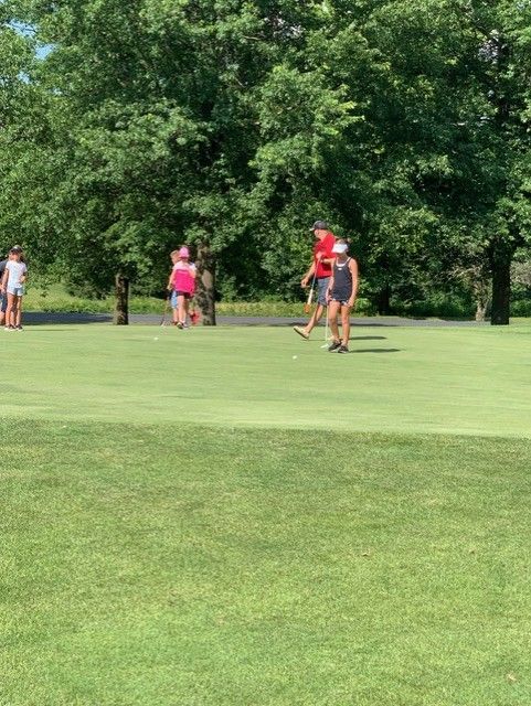 A group of people are playing golf on a golf course.