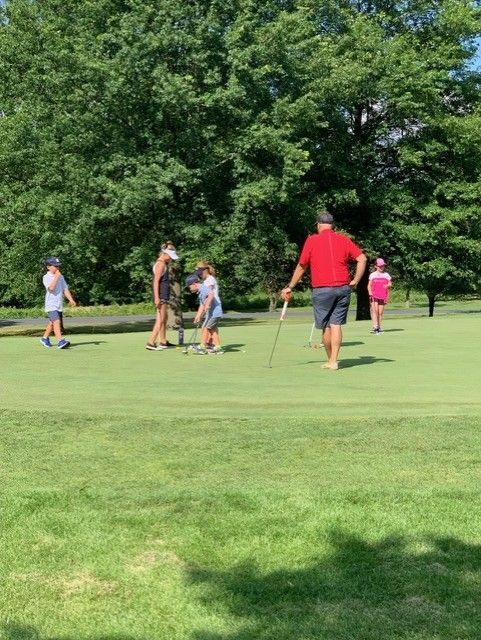 A group of people are playing golf on a golf course.