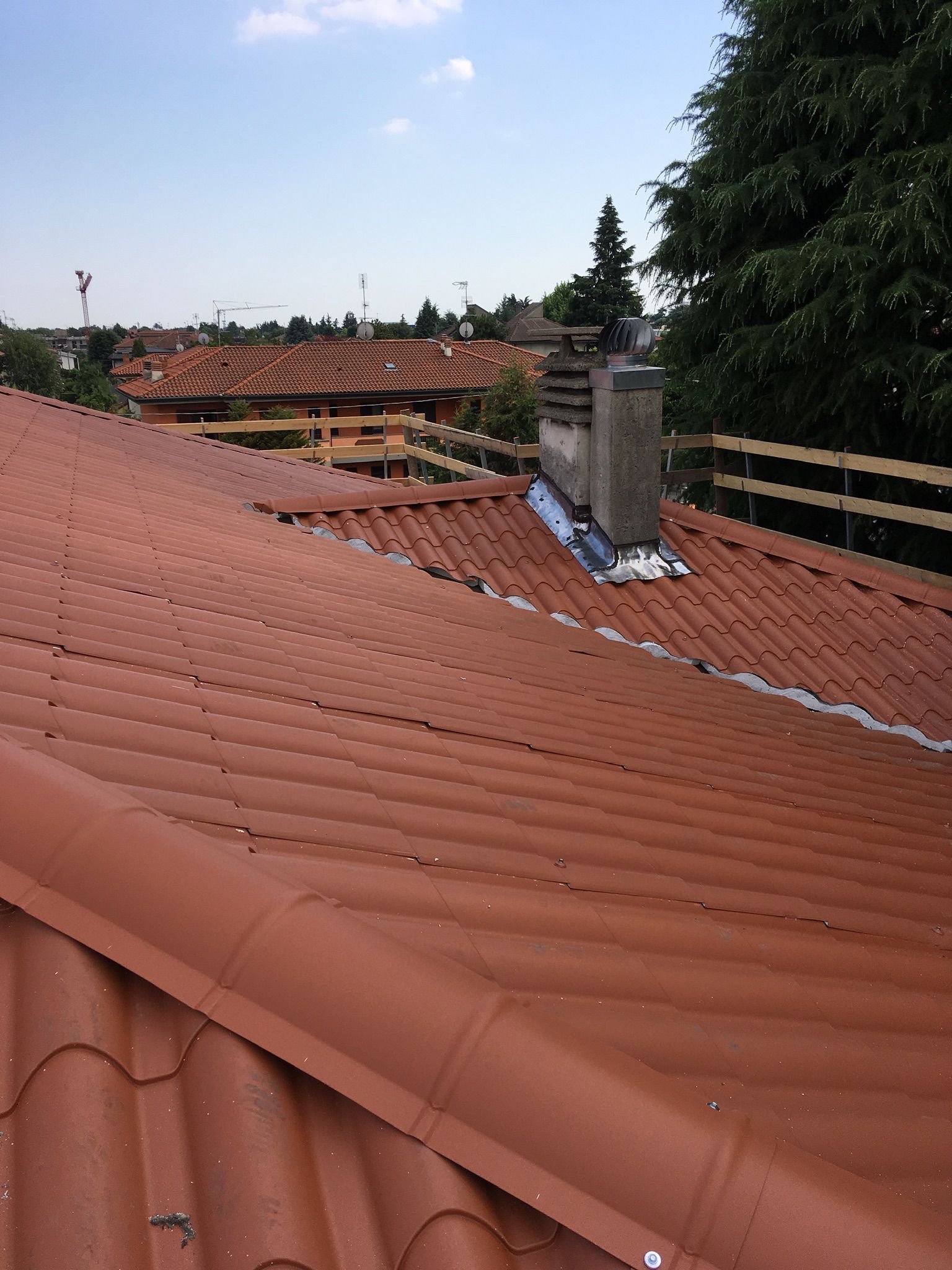 Griglia da esterno in mattoni con elementi in acciaio inox sotto una tettoia in legno.