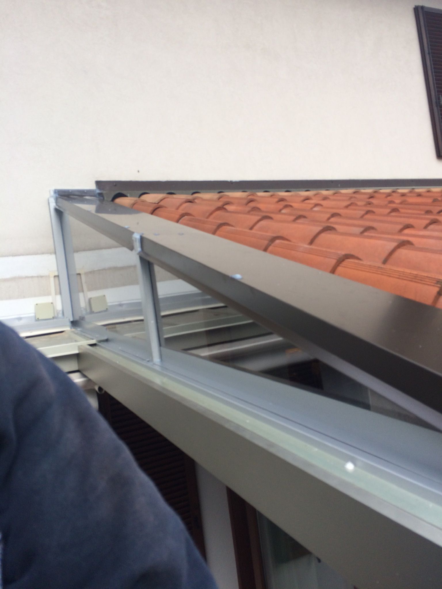 Tetto in lamiera ondulata rossa e bianca danneggiato. 