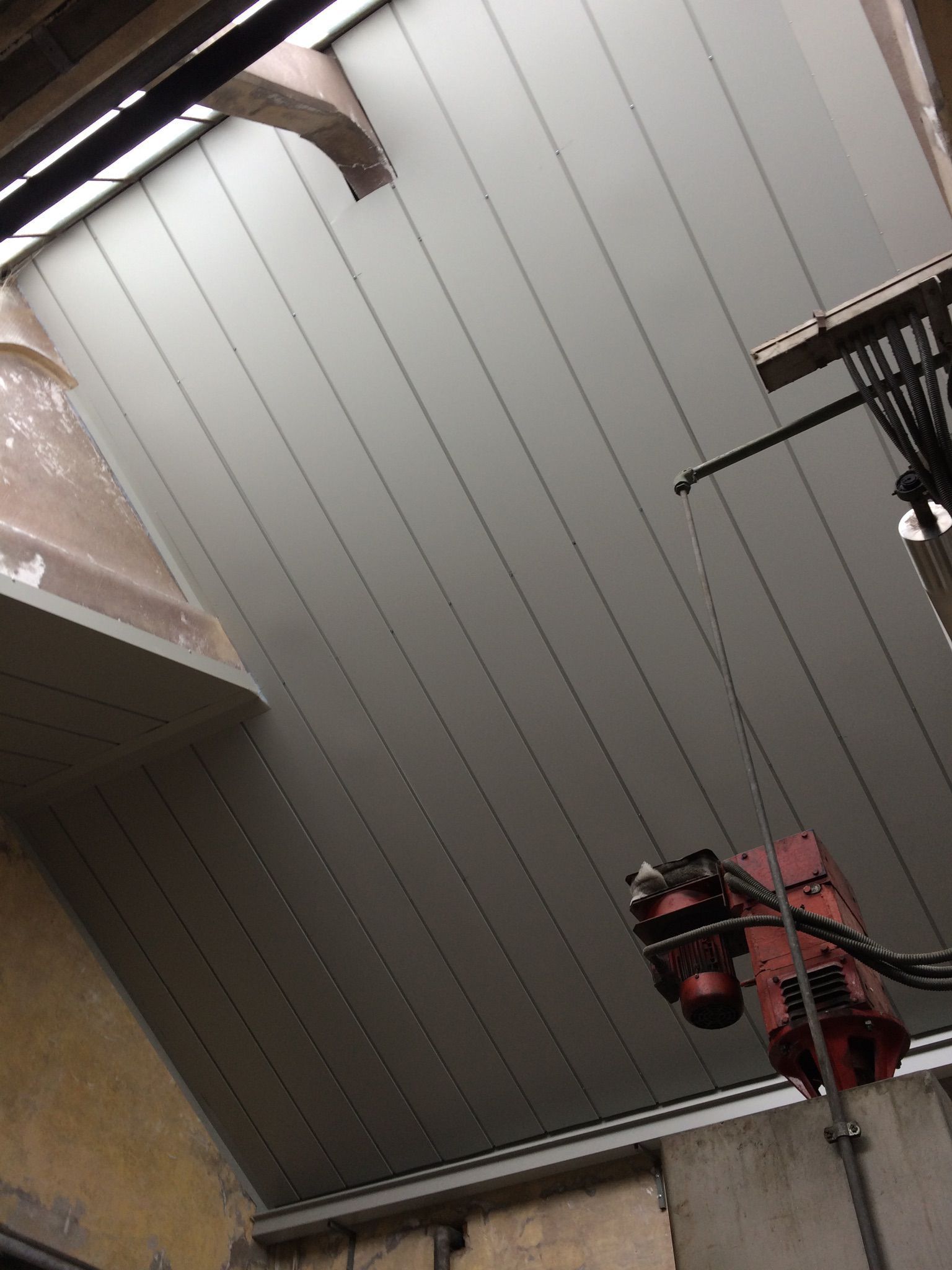 Struttura in legno con travi a vista e isolamento sul tetto di un edificio.