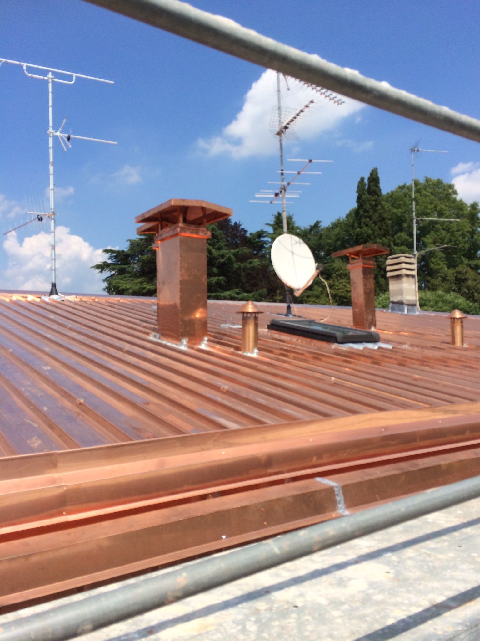 Tetto di tegole rosse con lucernario, case sullo sfondo, giorno.