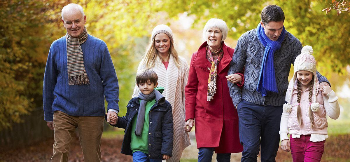 A family is walking together in the fall leaves