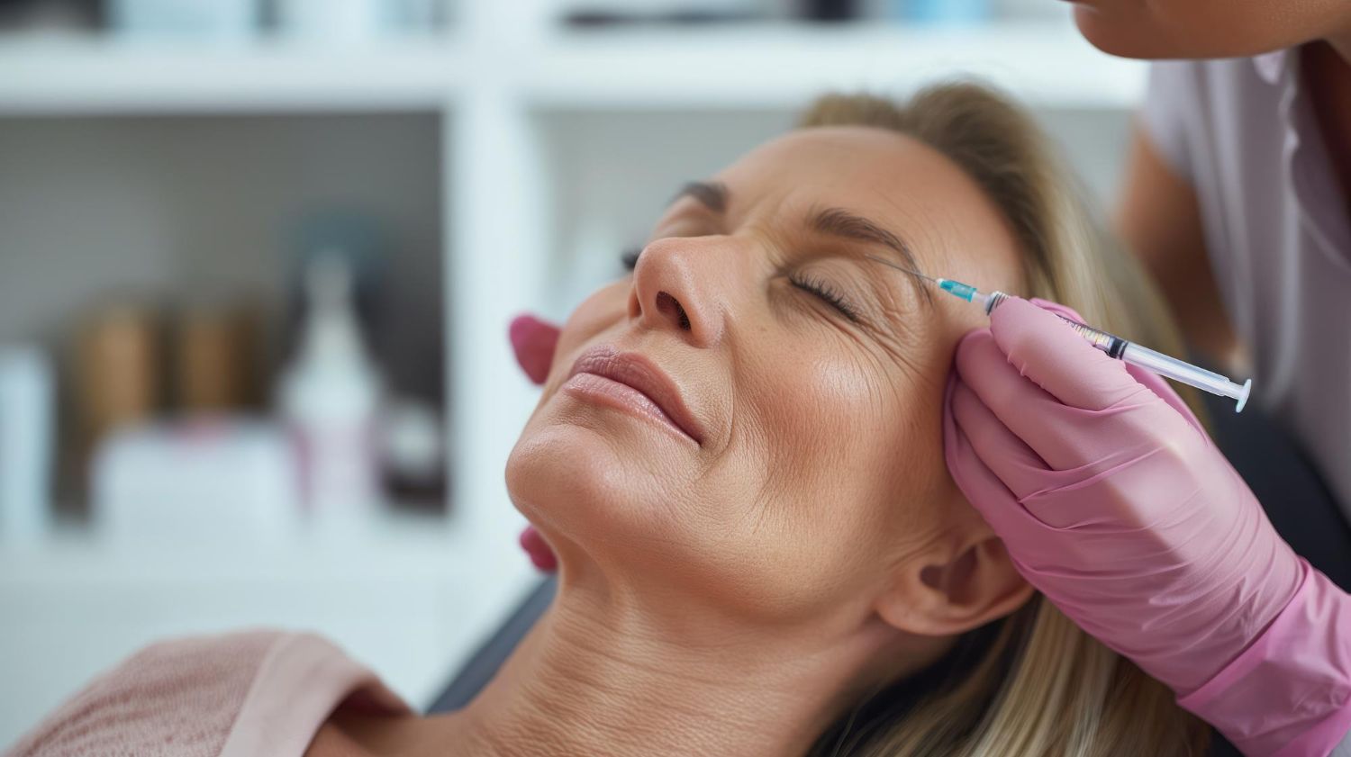 A woman is getting a botox injection in her forehead.