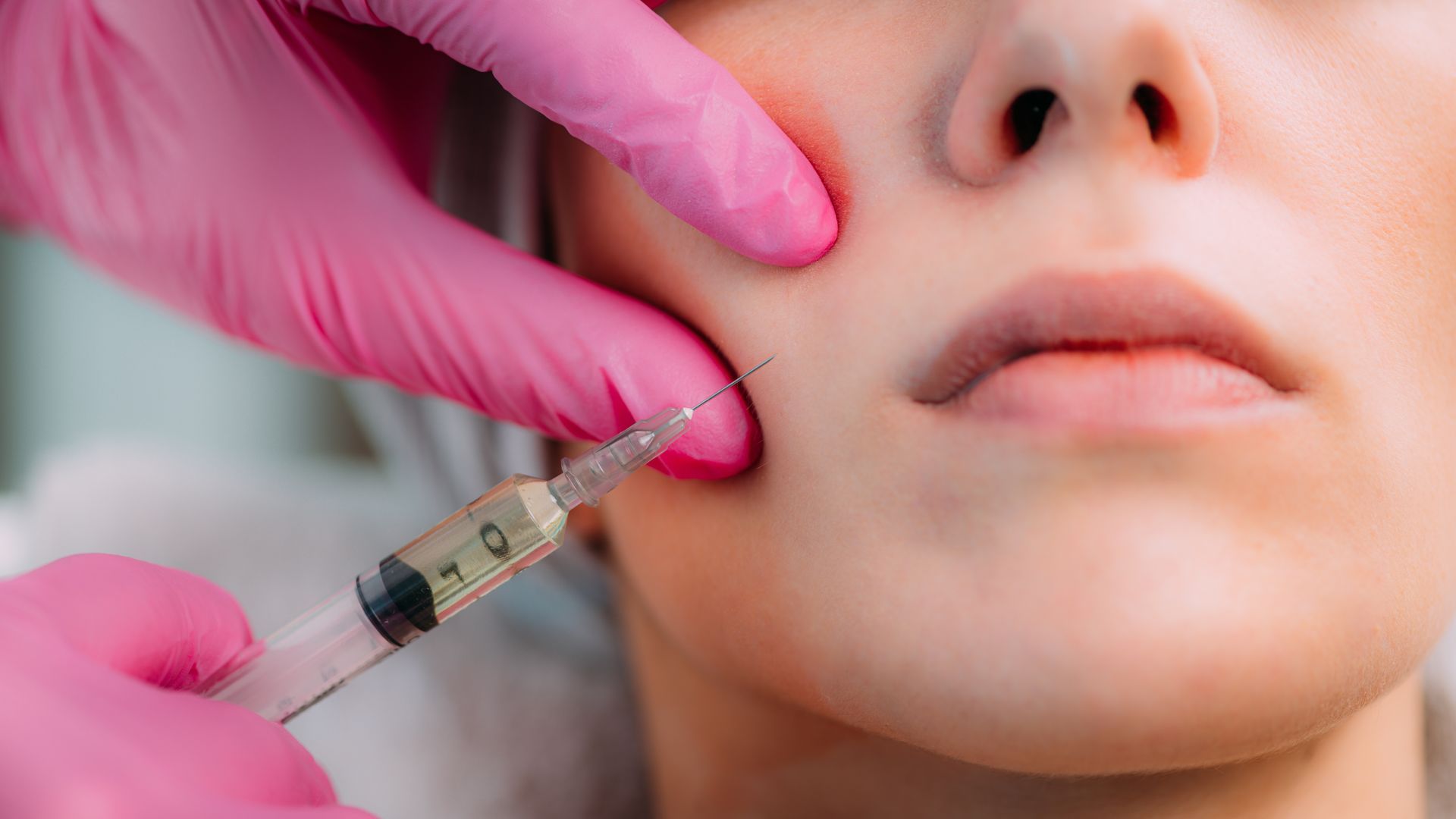 A woman is getting a botox injection in her face.