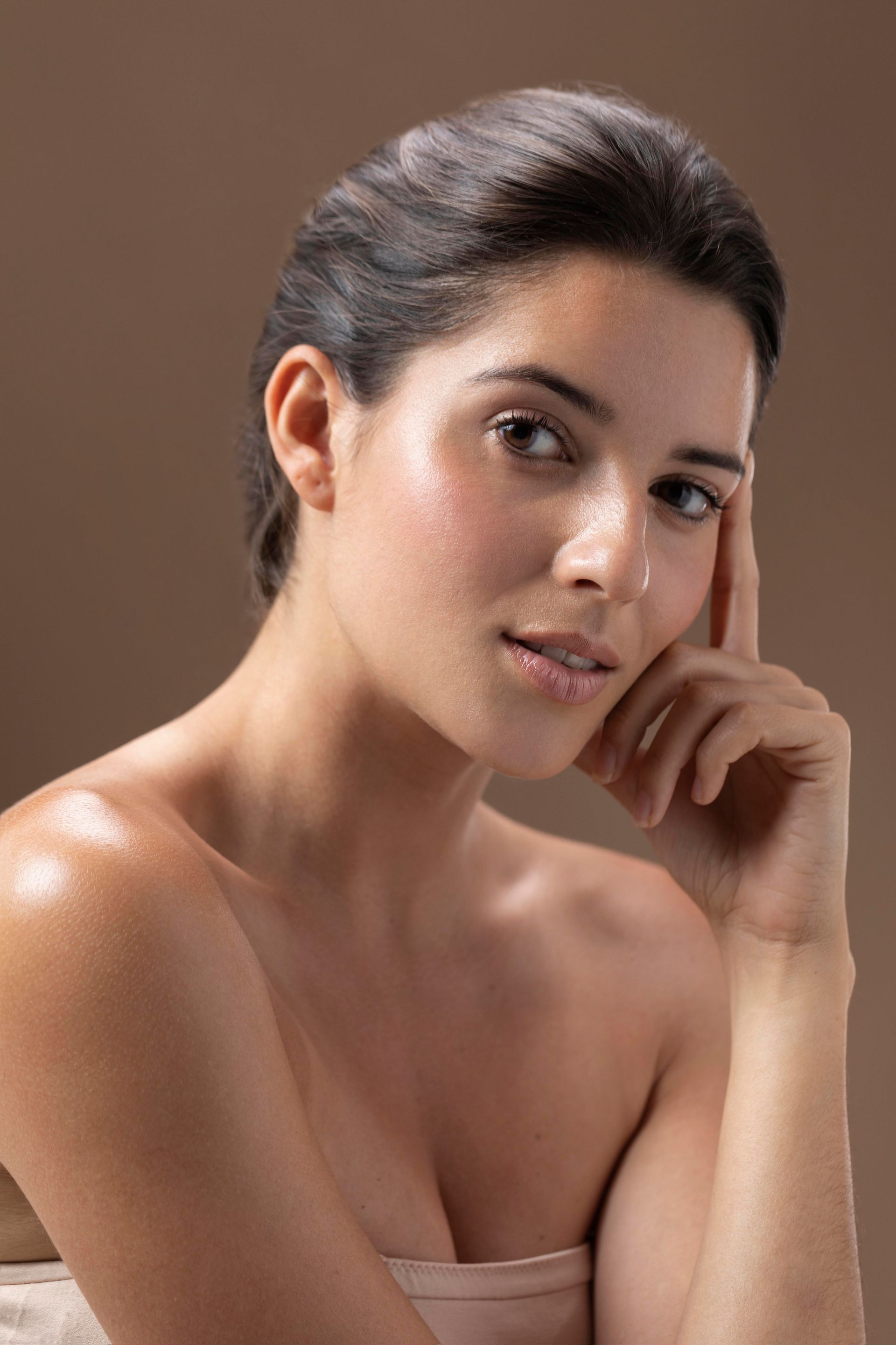 a close up of a woman 's face with her hand on her chin .