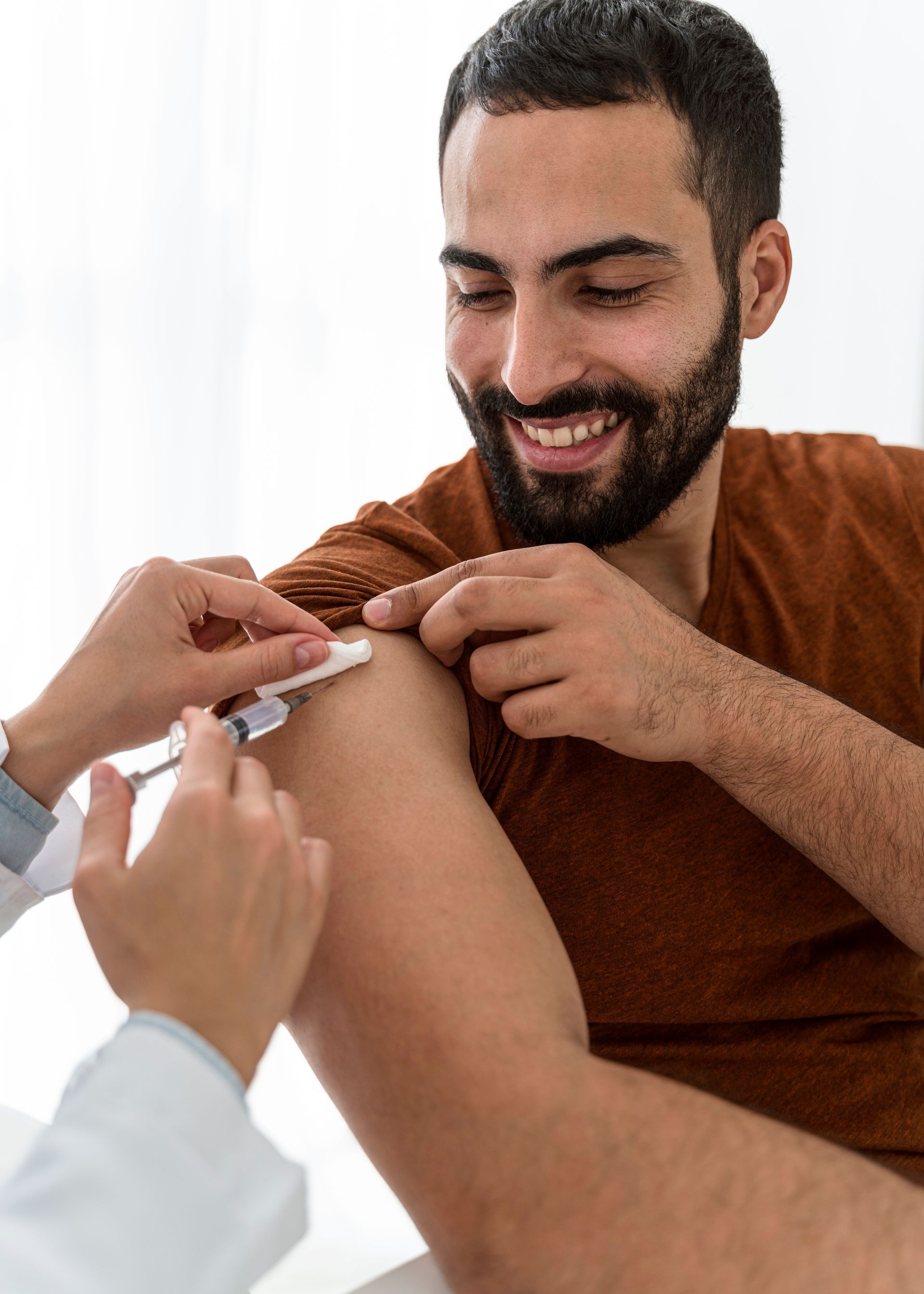 a man is getting an injection in his arm by a doctor .