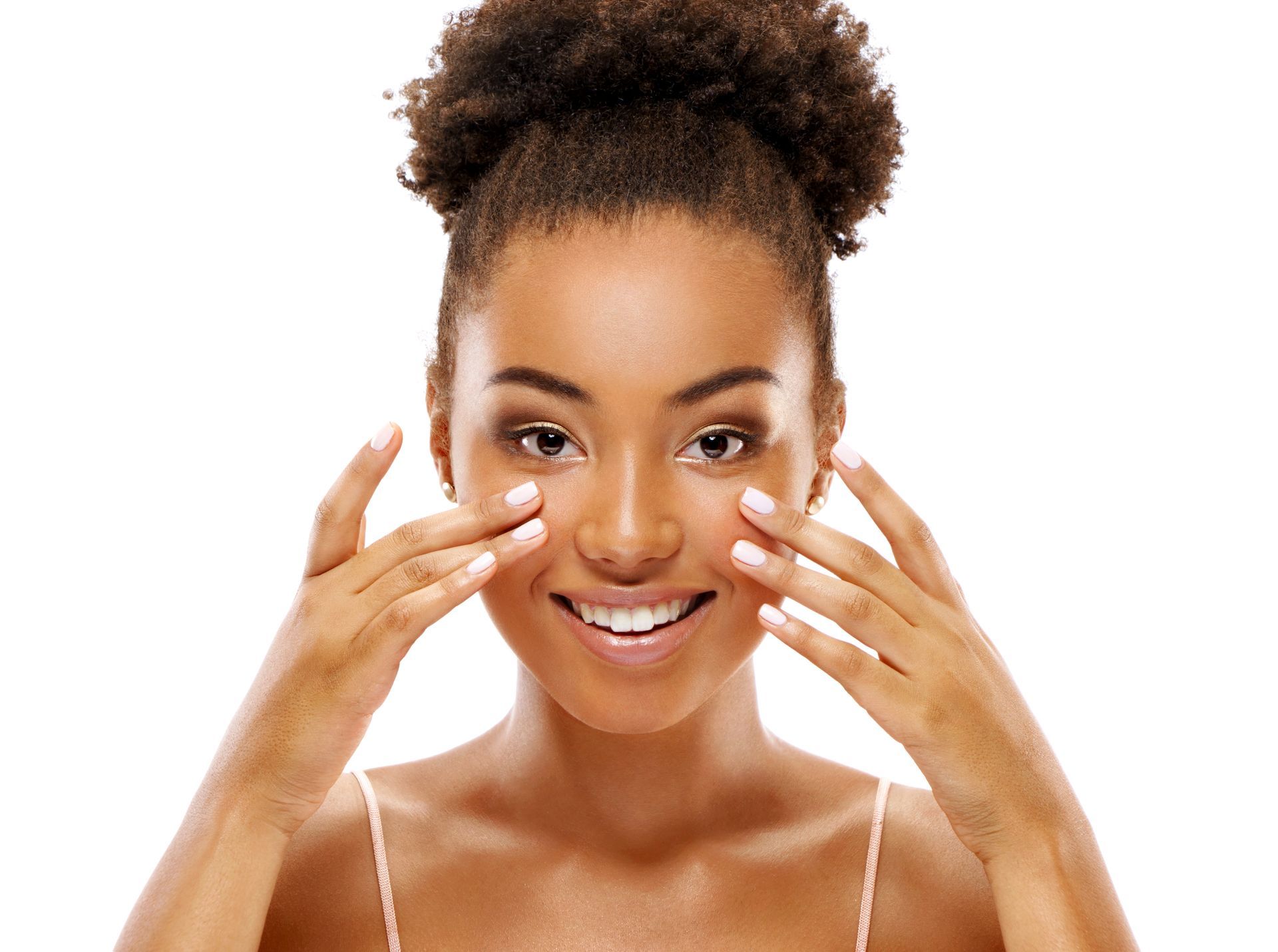 a woman is smiling and touching her face with her hands .