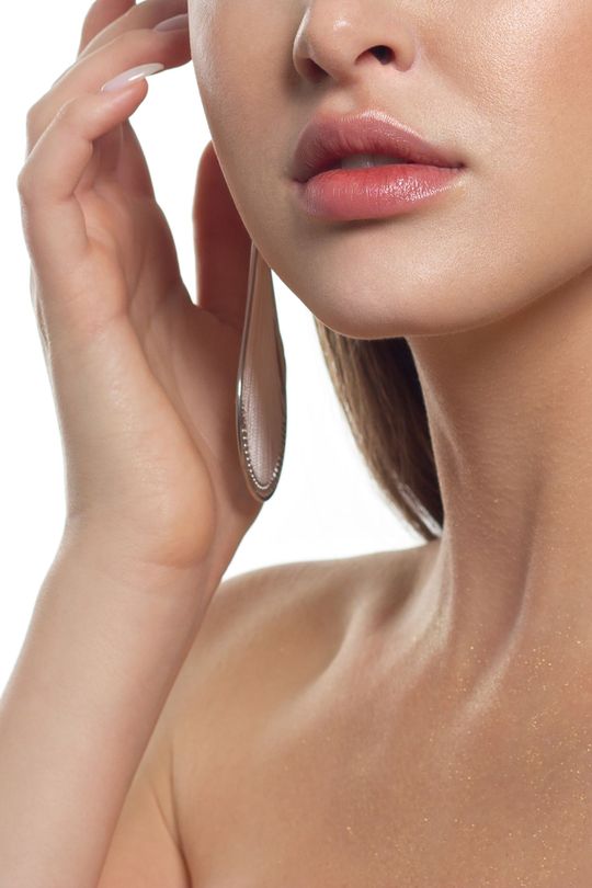 a close up of a woman 's face with her hand on her ear .