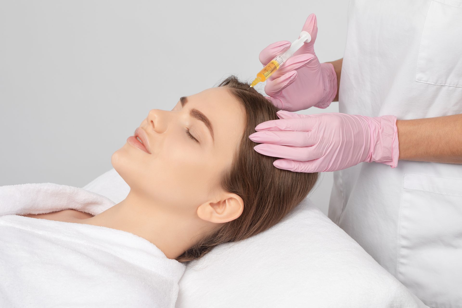 a woman is getting a hair treatment in a beauty salon .