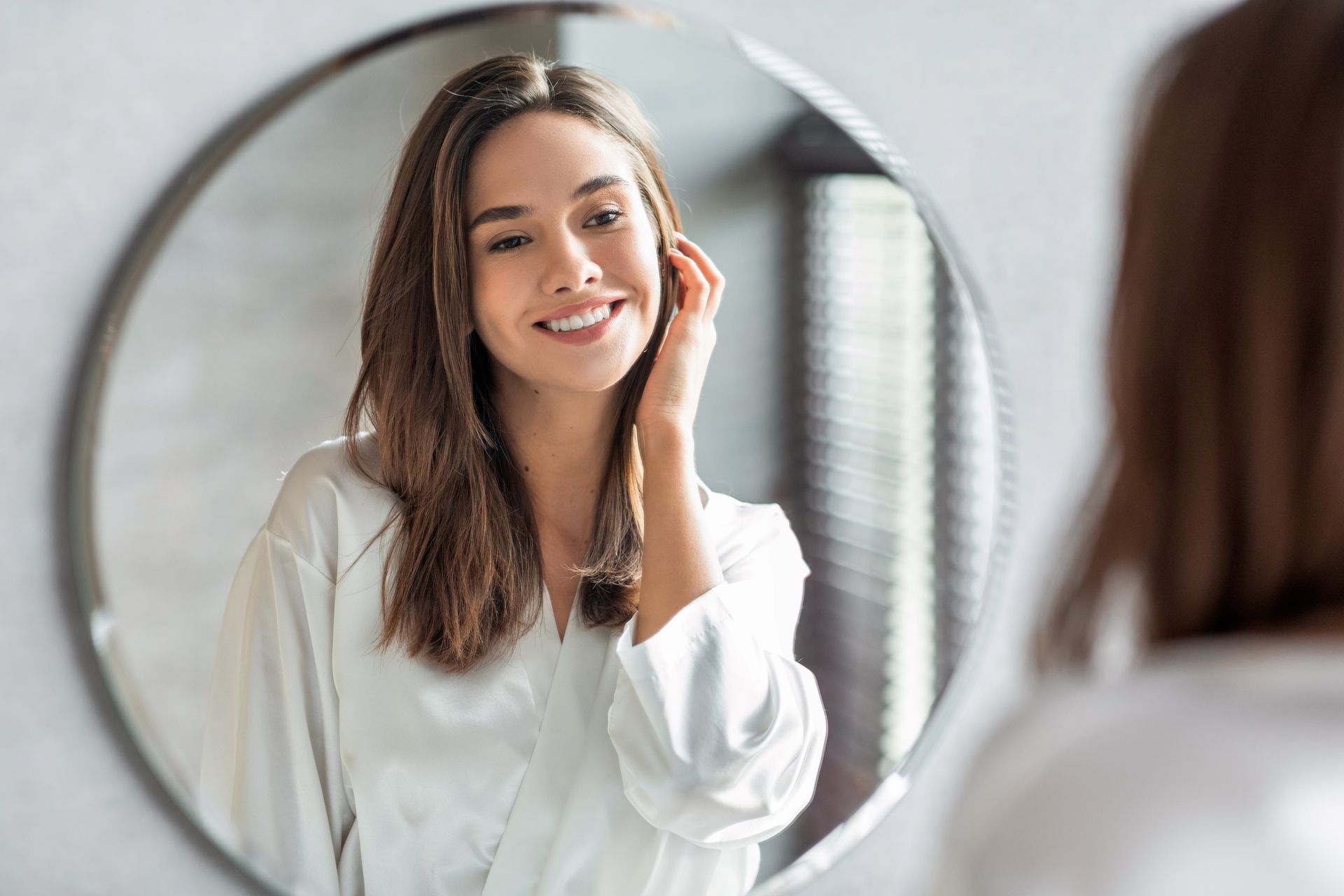 a woman is looking at herself in the mirror .