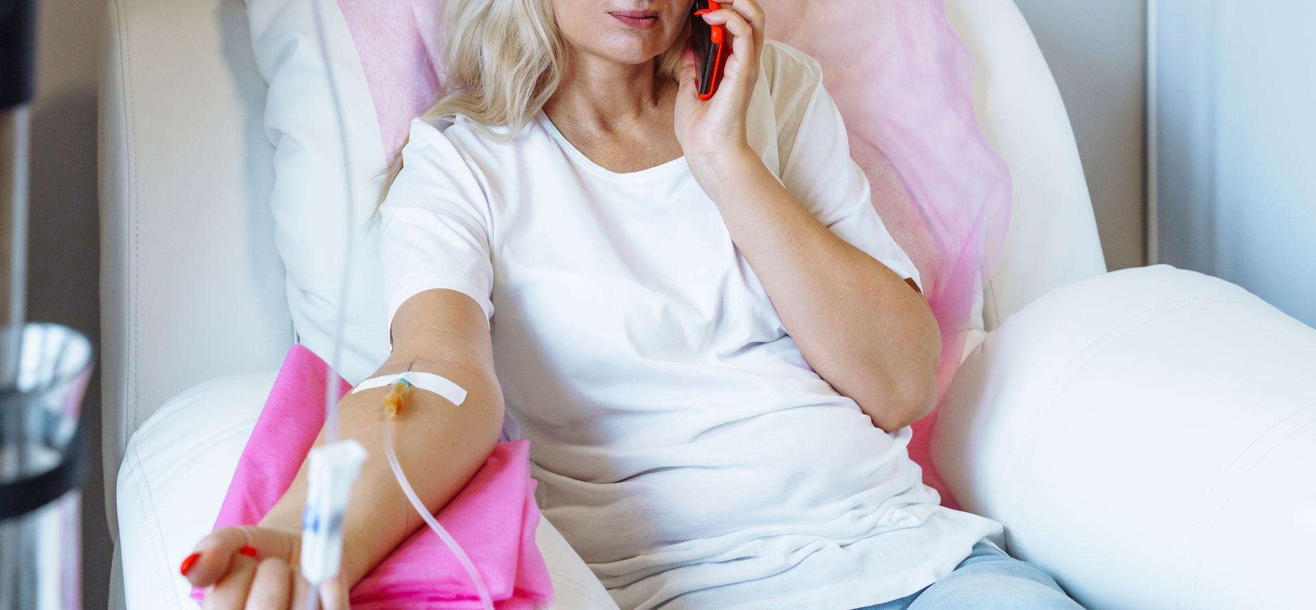 a woman is sitting in a hospital bed talking on a cell phone .