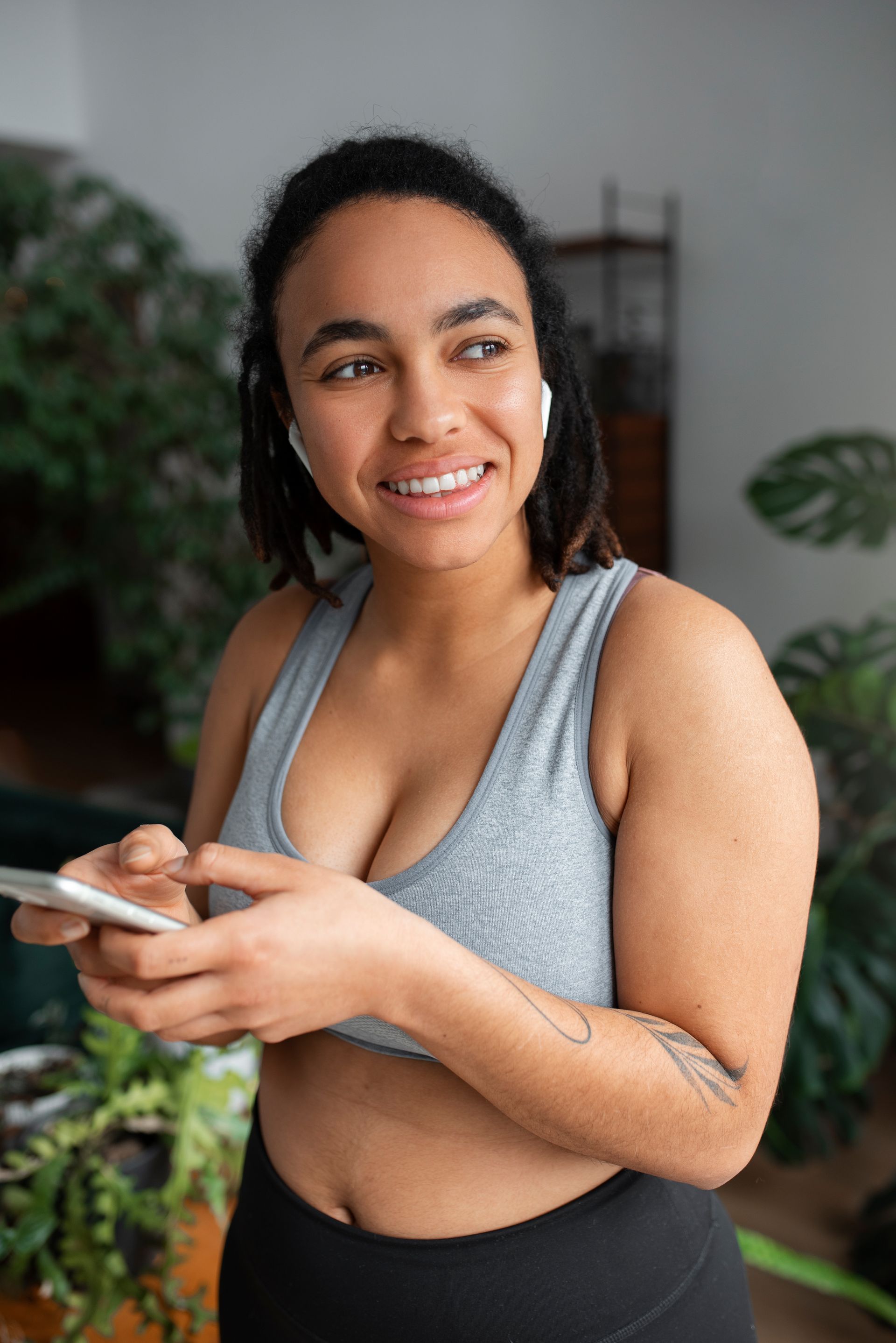 a woman is wearing headphones and using a cell phone .