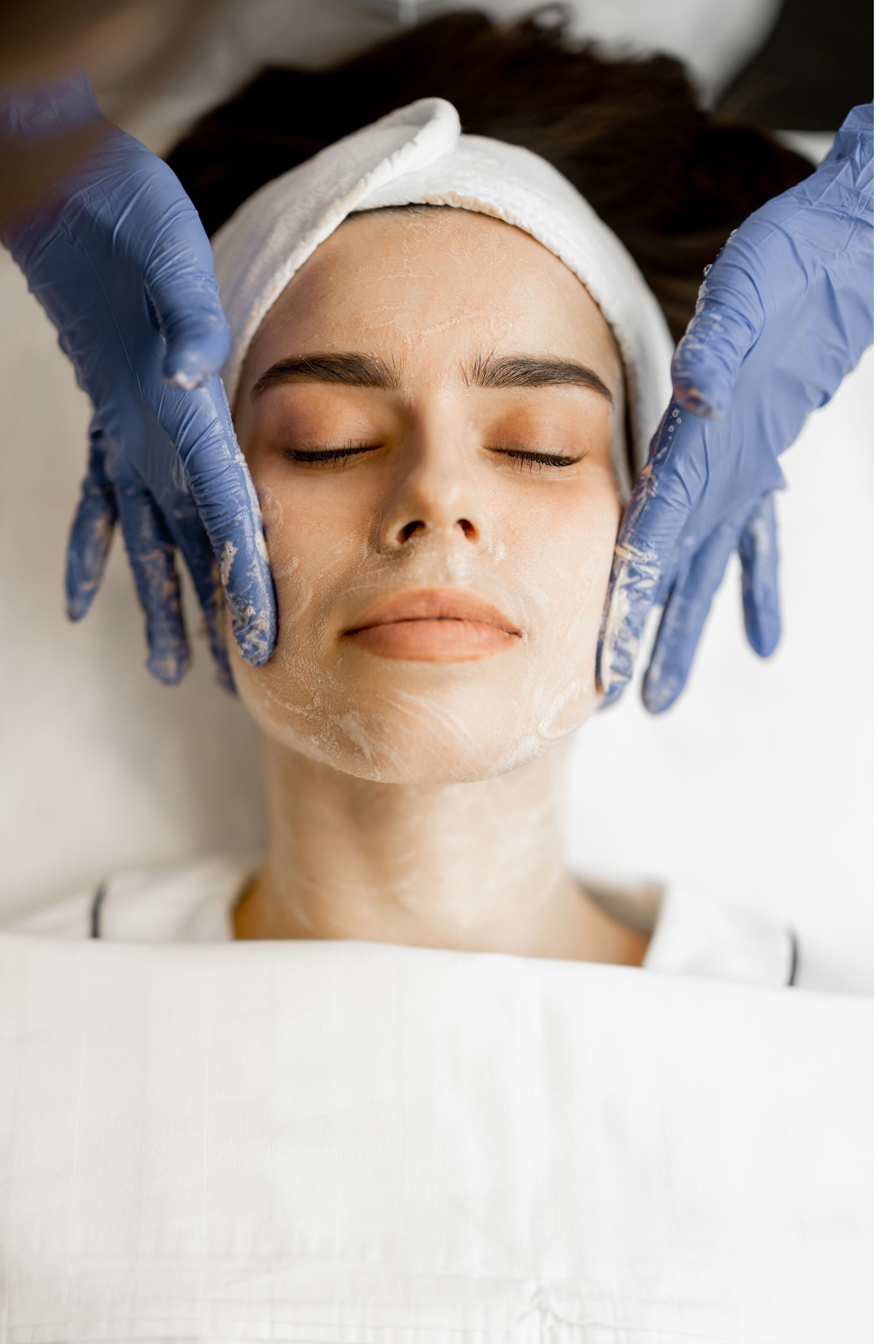 A woman is getting a facial treatment at a beauty salon.