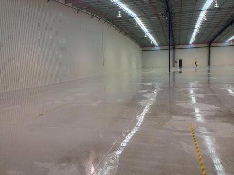 CONCRETE SEALING: Cleaning warehouse floor before applying a sealer.