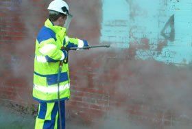 Industrial high pressure cleaning and pressure washing of brick wall.