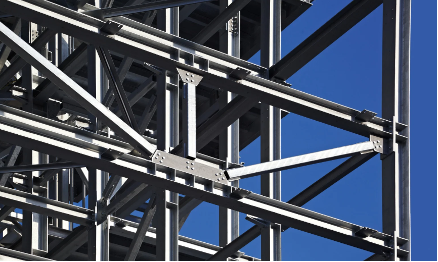 Steel beams and girders of a building under construction, against a clear blue sky.